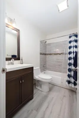 a bathroom with a sink toilet and a mirror at Chic with Recliner at Webster Hill Suite 1W Request Xtra Bed in New Britain