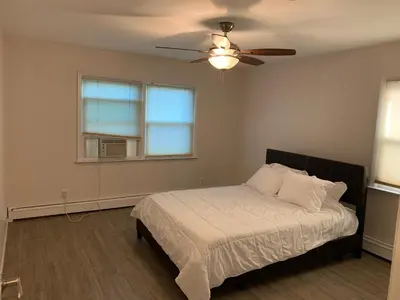 a bedroom with a bed and a ceiling fan at La Casita Bonita Near NYC in Yonkers