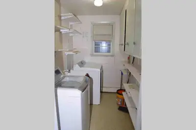 a small kitchen with a sink and a washing machine at La Casita Bonita Near NYC in Yonkers