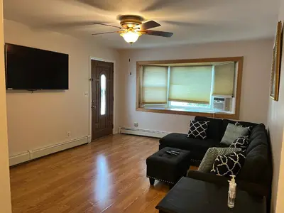 a living room with a couch and a flat screen tv at La Casita Bonita Near NYC in Yonkers