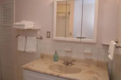 a bathroom with a sink and a mirror and towels at La Casita Bonita Near NYC in Yonkers
