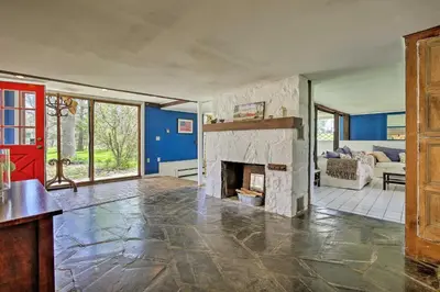 an empty living room with a stone fireplace at Charming Tivoli Home with Patio, by Town and Shops in Tivoli