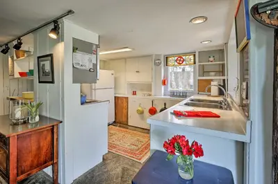 a kitchen with a vase of red flowers on a table at Charming Tivoli Home with Patio, by Town and Shops in Tivoli