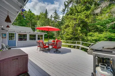 a patio with a table and chairs and an umbrella at Charming Wilmington Cabin, 8 Mi to Mt Snow! in Wilmington