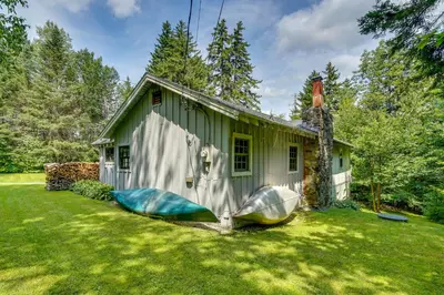 a green house with two infront of it at Charming Wilmington Cabin, 8 Mi to Mt Snow! in Wilmington