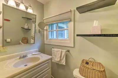 a bathroom with a sink and a mirror and a toilet at Charming Wilmington Cabin, 8 Mi to Mt Snow! in Wilmington