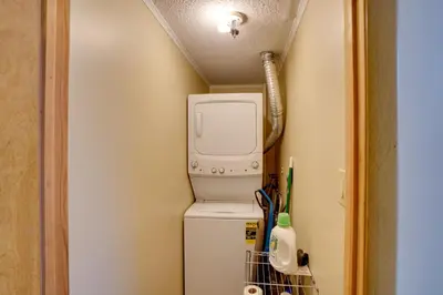a small kitchen with a washer and dryer next to a refrigerator at Catskills Home, 5 Mins to Windham Mtn Resort! in Windham