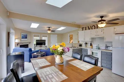 a kitchen and dining room with a table with flowers on it at Catskills Home, 5 Mins to Windham Mtn Resort! in Windham