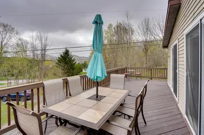 a patio table with an umbrella on a deck at Catskills Home, 5 Mins to Windham Mtn Resort! in Windham