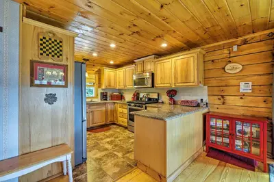 a kitchen with wooden cabinets and a counter top at Jacksonville Cabin with Wraparound Deck and Views in Jacksonville