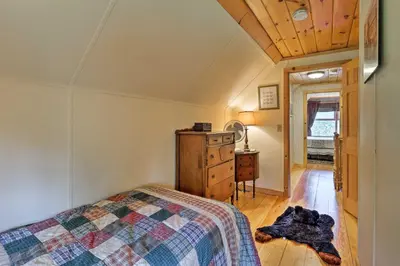 a bedroom with a bed and a wooden floor at Jacksonville Cabin with Wraparound Deck and Views in Jacksonville