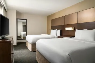 a hotel room with two beds and a flat screen tv at Residence Inn by Marriott Springfield Chicopee in Chicopee