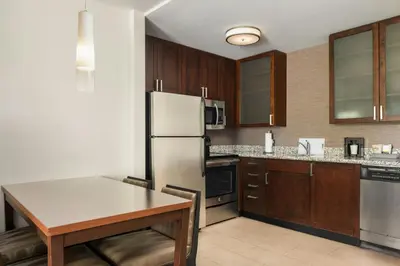 a kitchen with a table and a refrigerator at Residence Inn by Marriott Springfield Chicopee in Chicopee
