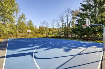an empty basketball court with a hoop at half Mi to Hideout Ski Lake Ariel Resort Home! in Lake Ariel