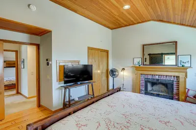 a bedroom with a large bed and a fireplace at Wilmington Retreat with Deck, Lake Views and Game Room in Wilmington