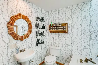 a bathroom with a toilet and a sink and a mirror at Wilmington Retreat with Deck, Lake Views and Game Room in Wilmington