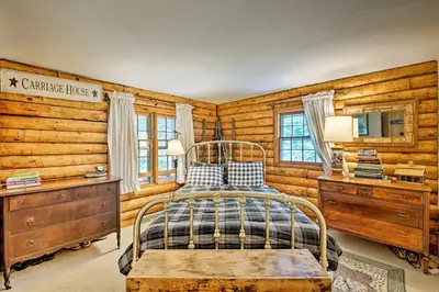 a bedroom with a bed and a wooden wall at Private Wooded Cabin 7 Mi to Mount Snow! in Wilmington
