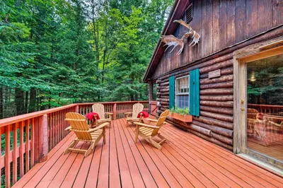 a wooden deck with rocking chairs on a cabin at Private Wooded Cabin 7 Mi to Mount Snow! in Wilmington