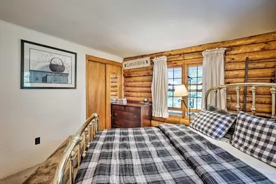 a bedroom with a bed and a wooden wall at Private Wooded Cabin 7 Mi to Mount Snow! in Wilmington