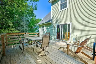 a wooden deck with a table and chairs on a house at West Dover Home with Deck, Grill and EV Outlet in West Dover