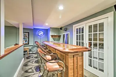 a kitchen with a bar with chairs around it at West Dover Home - 3 Miles to Mount Snow Resort! in West Dover