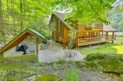 a large wooden cabin in the woods with a deck at Secluded Cabin with Boats Less Than 6 Mi to Jenny Jump! in Great Meadows