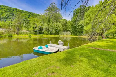 a small boat sitting in the middle of a lake at Secluded Cabin with Boats Less Than 6 Mi to Jenny Jump! in Great Meadows