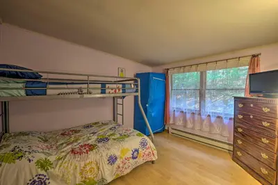 a bedroom with a bunk bed and a dresser and a window at Catskill Mtn Home with Deck about 1 Miles to Zoom Flume! in East Durham