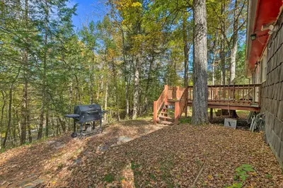 a backyard with a grill and a bridge and trees at Catskill Mtn Home with Deck about 1 Miles to Zoom Flume! in East Durham