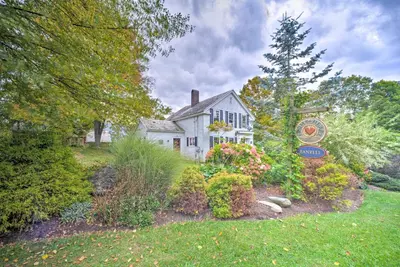 a white house with a sign in the yard at Manchester Center Home with Green Mtn Views! in Manchester Center