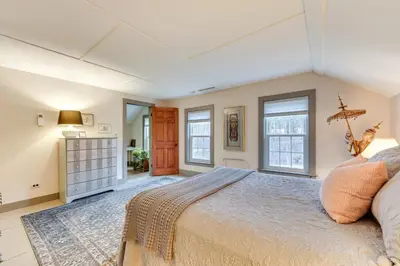 a bedroom with a large bed and two windows at Manchester Center Home with Green Mtn Views! in Manchester Center
