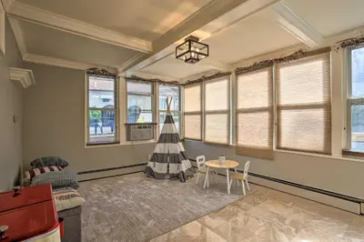 a living room with a table and chairs and windows at Lake Hopatcong Family Home with Boat Slip and Dock in Hopatcong