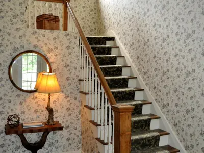 a stairway with a mirror and a lamp and a staircase at Anne's Washington Inn in Saratoga Springs