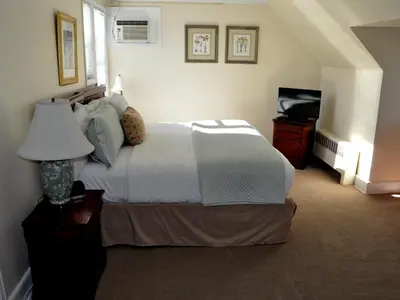 a bedroom with a bed with a lamp and a piano at Anne's Washington Inn in Saratoga Springs