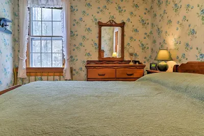 a bedroom with a bed and a mirror and a dresser at East Otis Reservoir Cabin with Porch - Walk to Lake! in East Otis