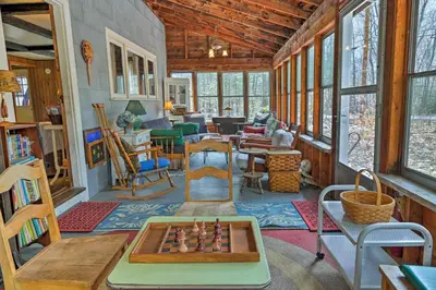 a living room with a table and chessboard in it at East Otis Reservoir Cabin with Porch - Walk to Lake! in East Otis