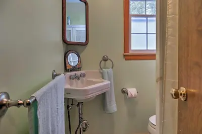 a bathroom with a sink and a mirror at East Otis Reservoir Cabin with Porch - Walk to Lake! in East Otis