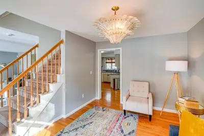 a living room with a chandelier and a chair at Walk to Dining Downtown Lenox Guest House! in Lenox
