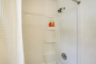 a bathroom with a shower with white tiles at Walk to Dining Downtown Lenox Guest House! in Lenox