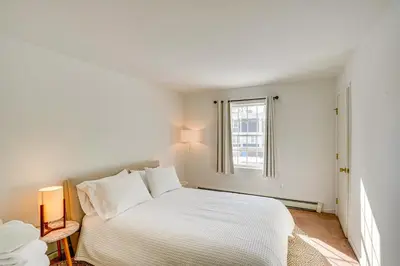 a white bedroom with a bed and a window at Walk to Dining Downtown Lenox Guest House! in Lenox