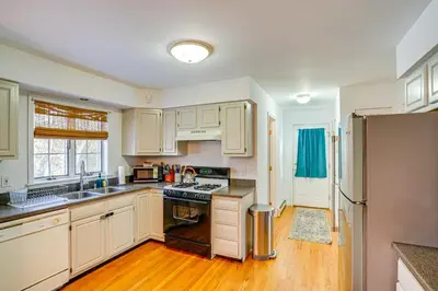 a kitchen with wooden floors and white cabinets at Walk to Dining Downtown Lenox Guest House! in Lenox