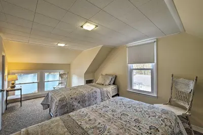 a bedroom with two beds and two windows at Picturesque Cottage with Sunroom on Ashmere Lake! in Hinsdale