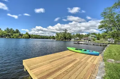 a canoe sitting on a dock on a lake at Picturesque Cottage with Sunroom on Ashmere Lake! in Hinsdale