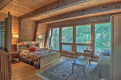 a bedroom with a bed in a room with windows at Lakefront Berkshires Retreat with Deck, Dock and Boat! in Great Barrington