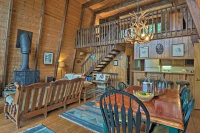 a dining room with a table and a staircase at Lakefront Berkshires Retreat with Deck, Dock and Boat! in Great Barrington