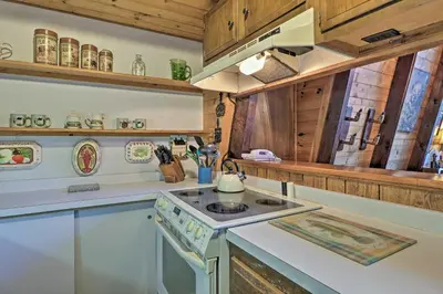 a kitchen with a stove top oven next to a counter at Lakefront Berkshires Retreat with Deck, Dock and Boat! in Great Barrington