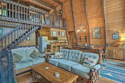 a living room with a couch and a table at Lakefront Berkshires Retreat with Deck, Dock and Boat! in Great Barrington