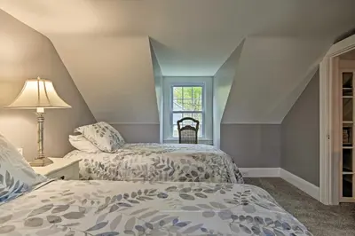 two beds in a attic room with a window at Beautiful Lenox Home, 3 Mi to Shakespeare and Co! in Lenox