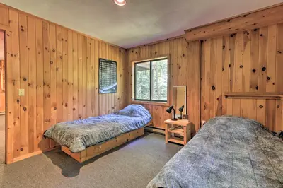 two beds in a room with wooden walls at Cabin with 3 Acres, Tennis Courts By 4 Ski Mtns in Sandisfield