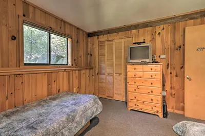 a bedroom with a bed and a tv on a dresser at Cabin with 3 Acres, Tennis Courts By 4 Ski Mtns in Sandisfield
